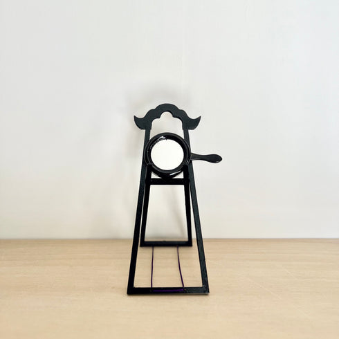 A small hand mirror and its stand