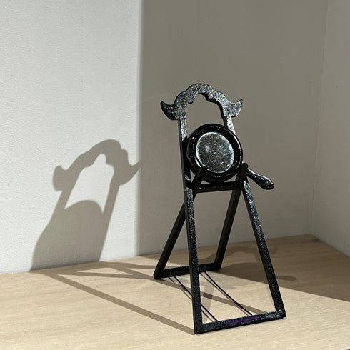 A small hand mirror and its stand